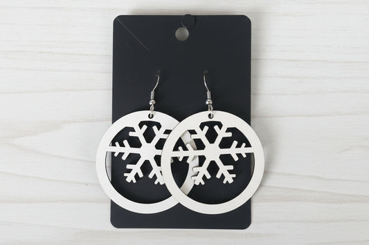 Two wooden snowflake designs on a black background