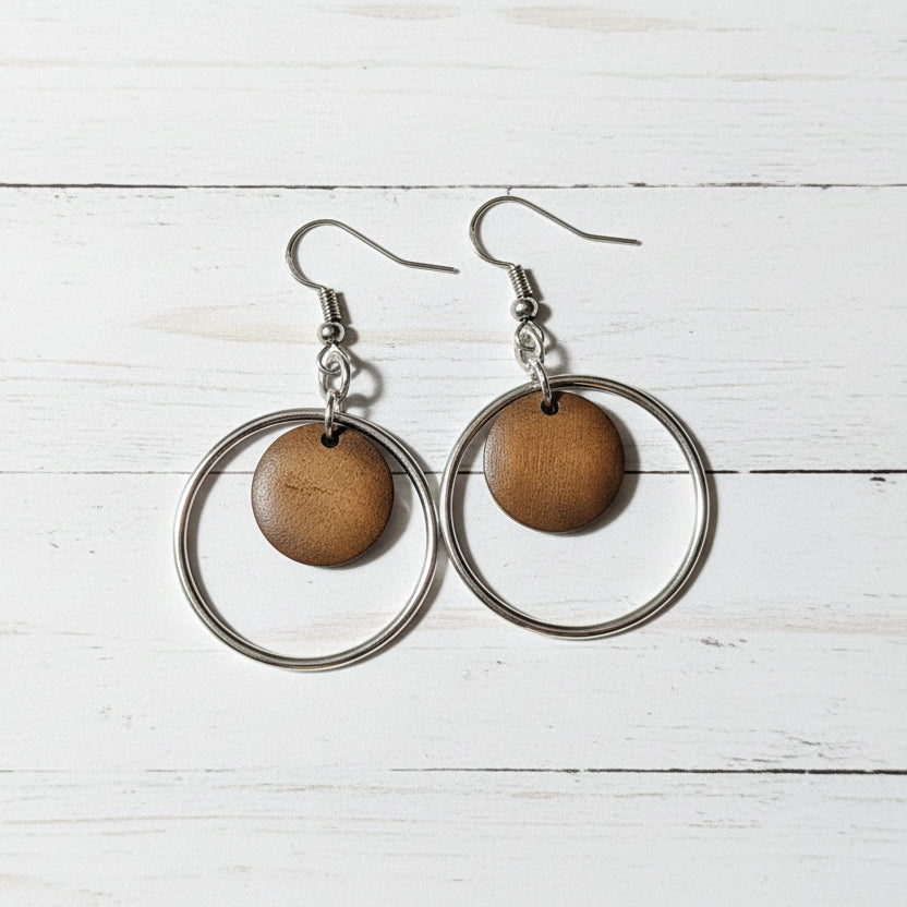 Wooden circle earrings on a white wooden surface