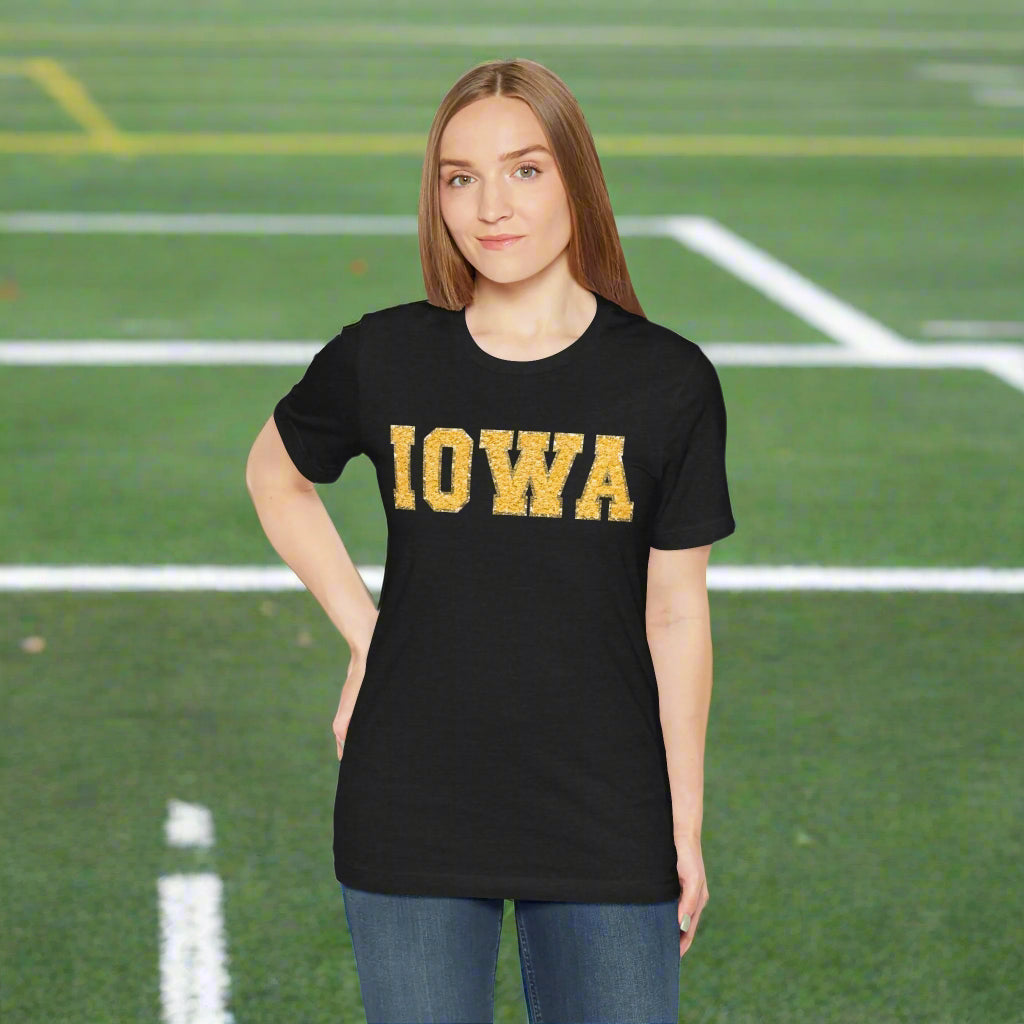 Person wearing a black t-shirt with 'IOWA' printed in yellow on a white background