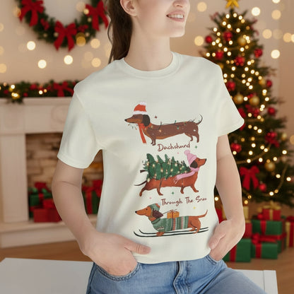 Person wearing a citron t-shirt with Christmas-themed dachshund graphics