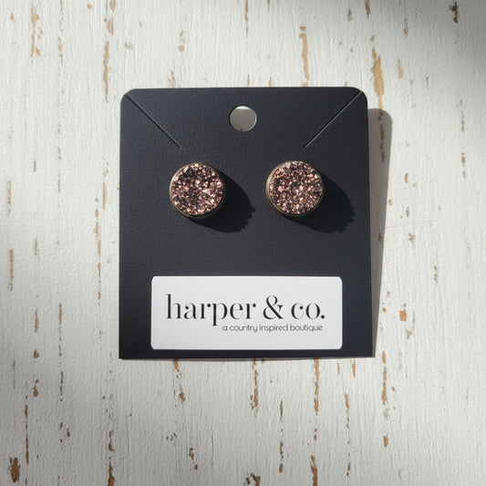 Pair of round earrings with a glittery finish on a black card with 'harper & co.' branding.