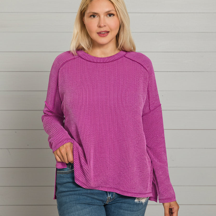 Woman wearing a pink sweater against a gray wooden panel background