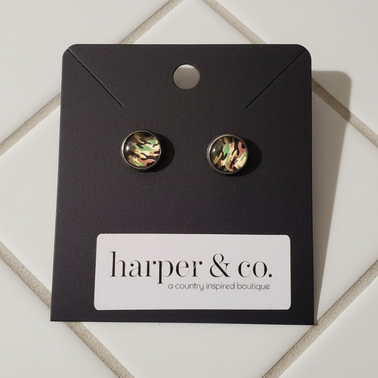 Pair of earrings on a black card with 'harper & co.' label on a wooden surface