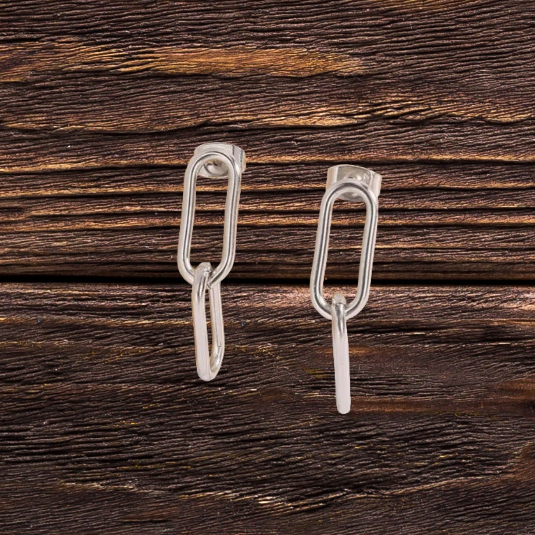 Pair of silver earrings on a wooden surface