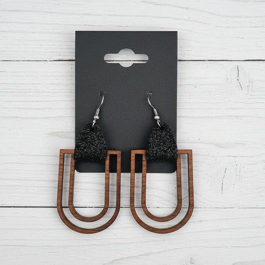Wooden U-shaped earrings with metallic accents on a black card.