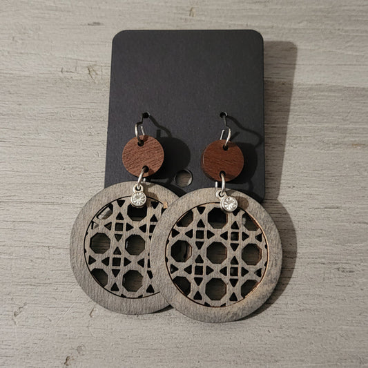 Wooden earrings with geometric patterns on a wooden surface
