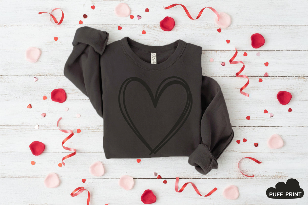 Black sweatshirt with a heart design on a wooden background