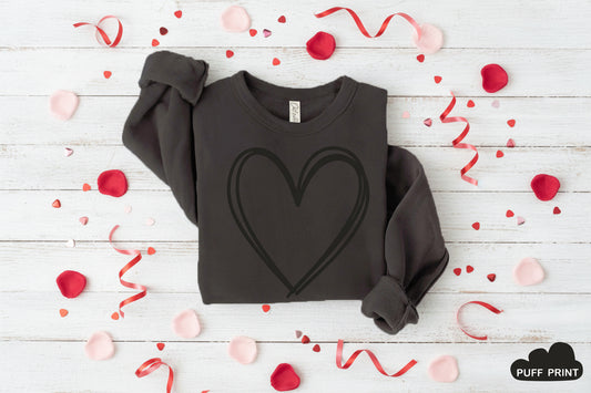 Black sweatshirt with a heart design on a wooden background