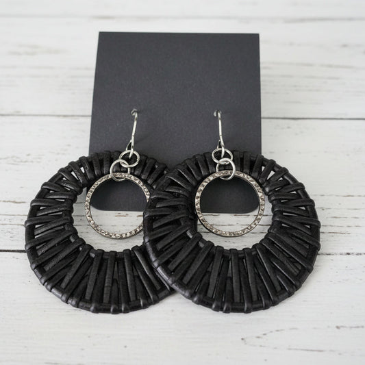 Black circular earrings on a wooden surface