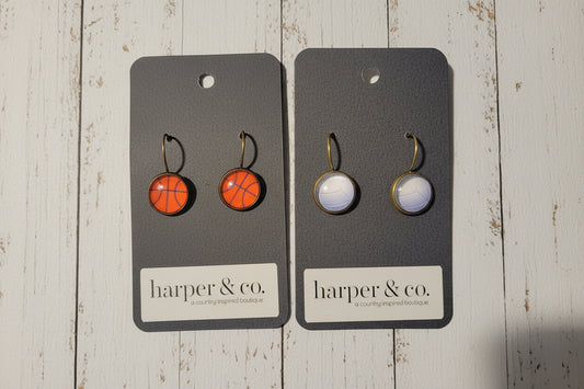 Two pairs of earrings on black cards with 'harper & co' branding on a textured surface.