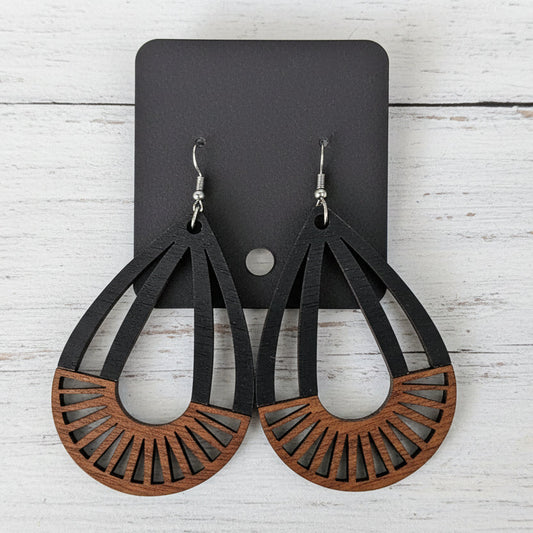 Wooden earrings with a geometric design on a white surface.