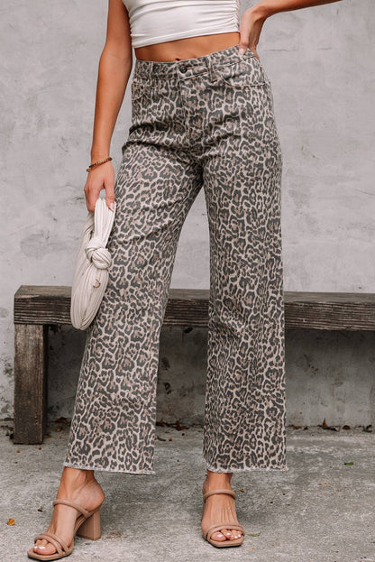 Person wearing leopard print pants sitting on a bench with a neutral background